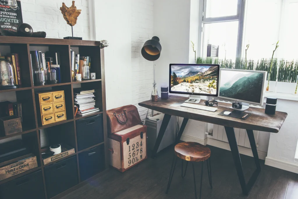 Arbeitsplatz mit zwei Bildschirmen und Regalen
