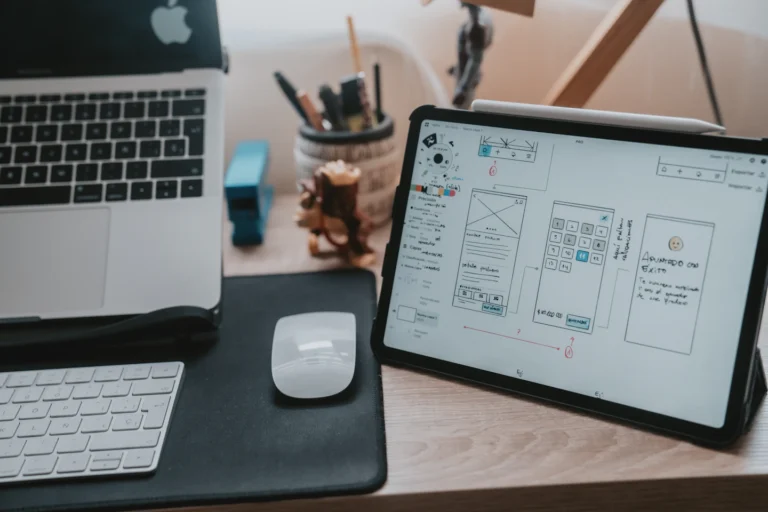 Digitaler Arbeitsplatz mit Tablet, Laptop und Konzeptskizzen
